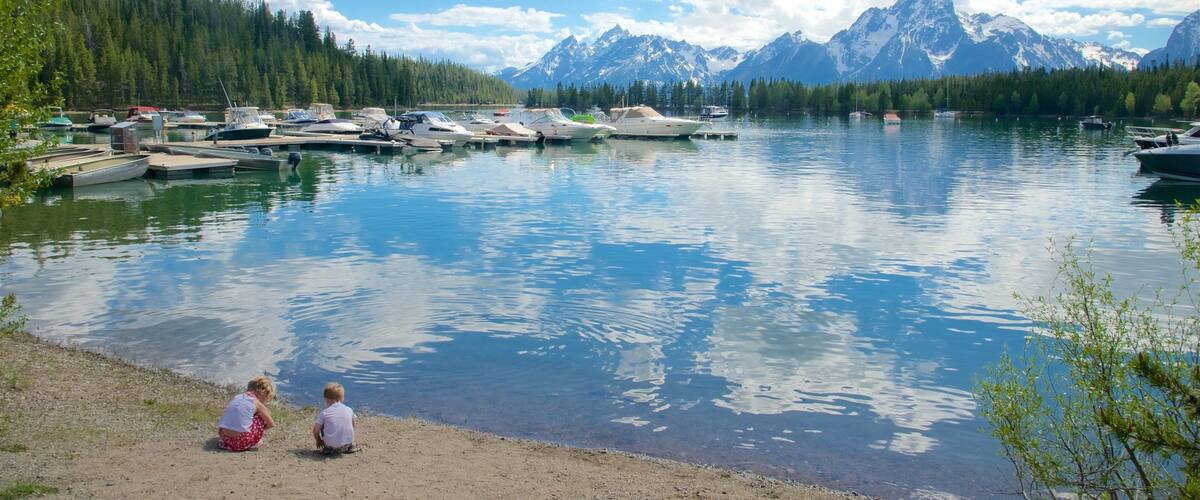 Centro de visitantes de Colter Bay mostrando un lago o abrevadero y una bahía o puerto y también niños
