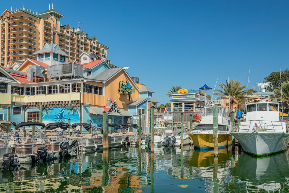Un puerto deportivo con barcos amarrados, un edificio grande con un mural y un letrero de Margaritaville.
