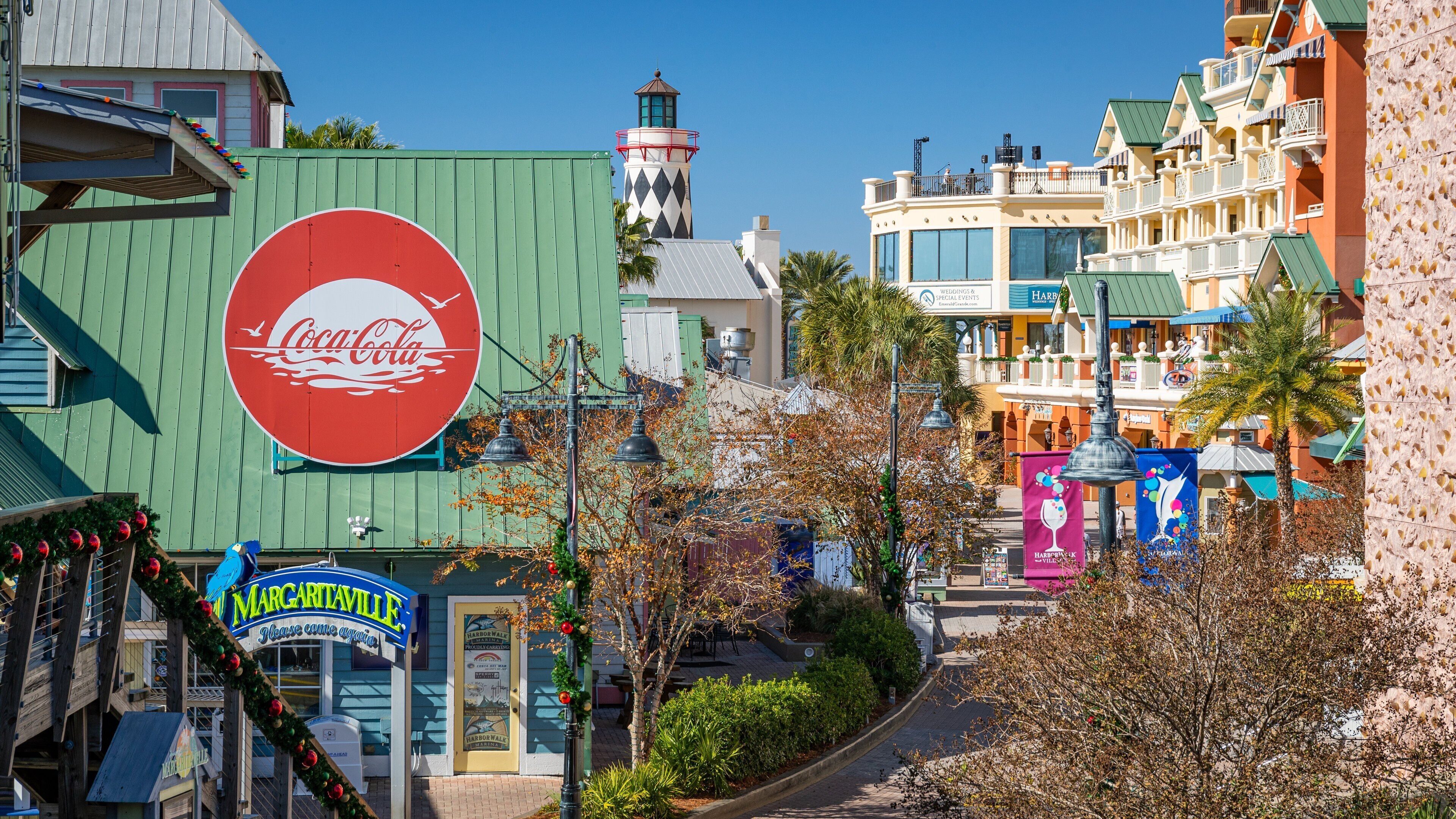 Een Coca-Cola bord, een vuurtoren en een gebouw met een bord waarop 'Harborwalk' staat.