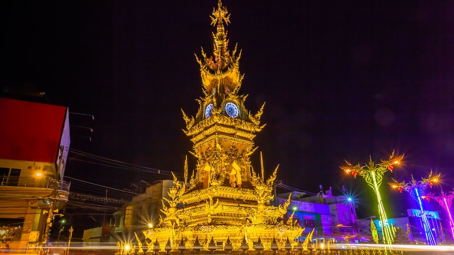 sunset at clock tower in Chiang Rai town. beautiful sculpture clock tower in central of Chiang Rai city.the color of clock tower start to change in twilight