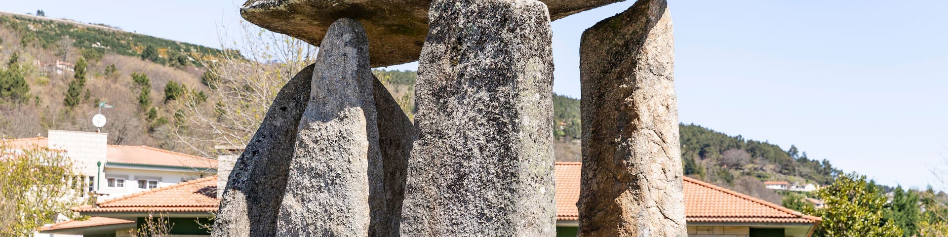 A stone structure with a circular top and four vertical pillars.