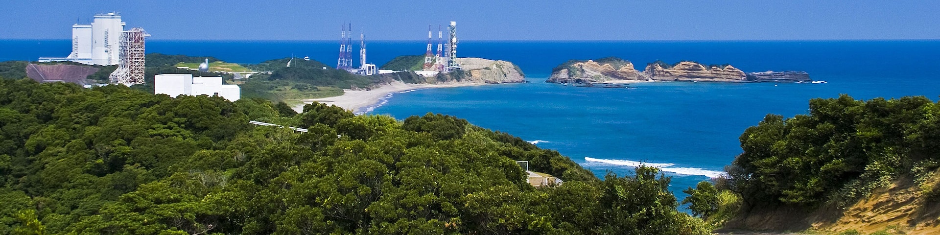 緑の山と珊瑚礁の海に囲まれた大崎射場を望む。