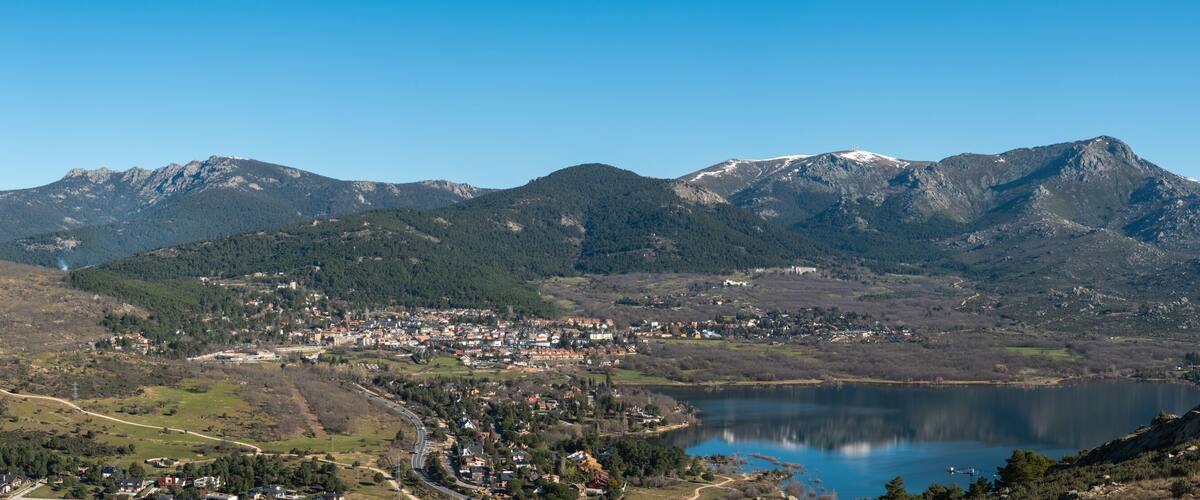 A mountainous landscape with a lake and a town in the valley.