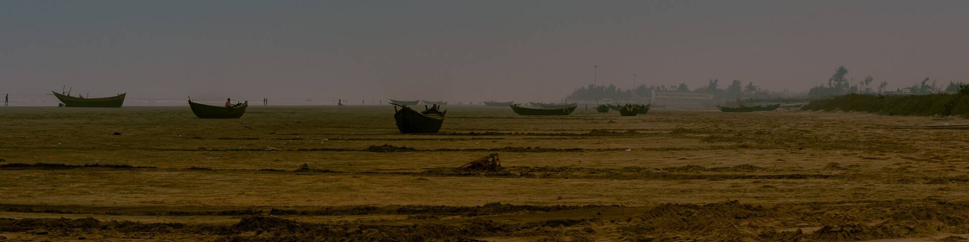 Landscape View of Sea Beach with Silhouette boats at the time of Dawn.