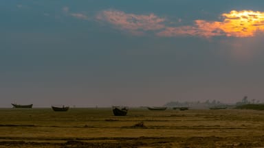 Landscape View of Sea Beach with Silhouette boats at the time of Dawn.