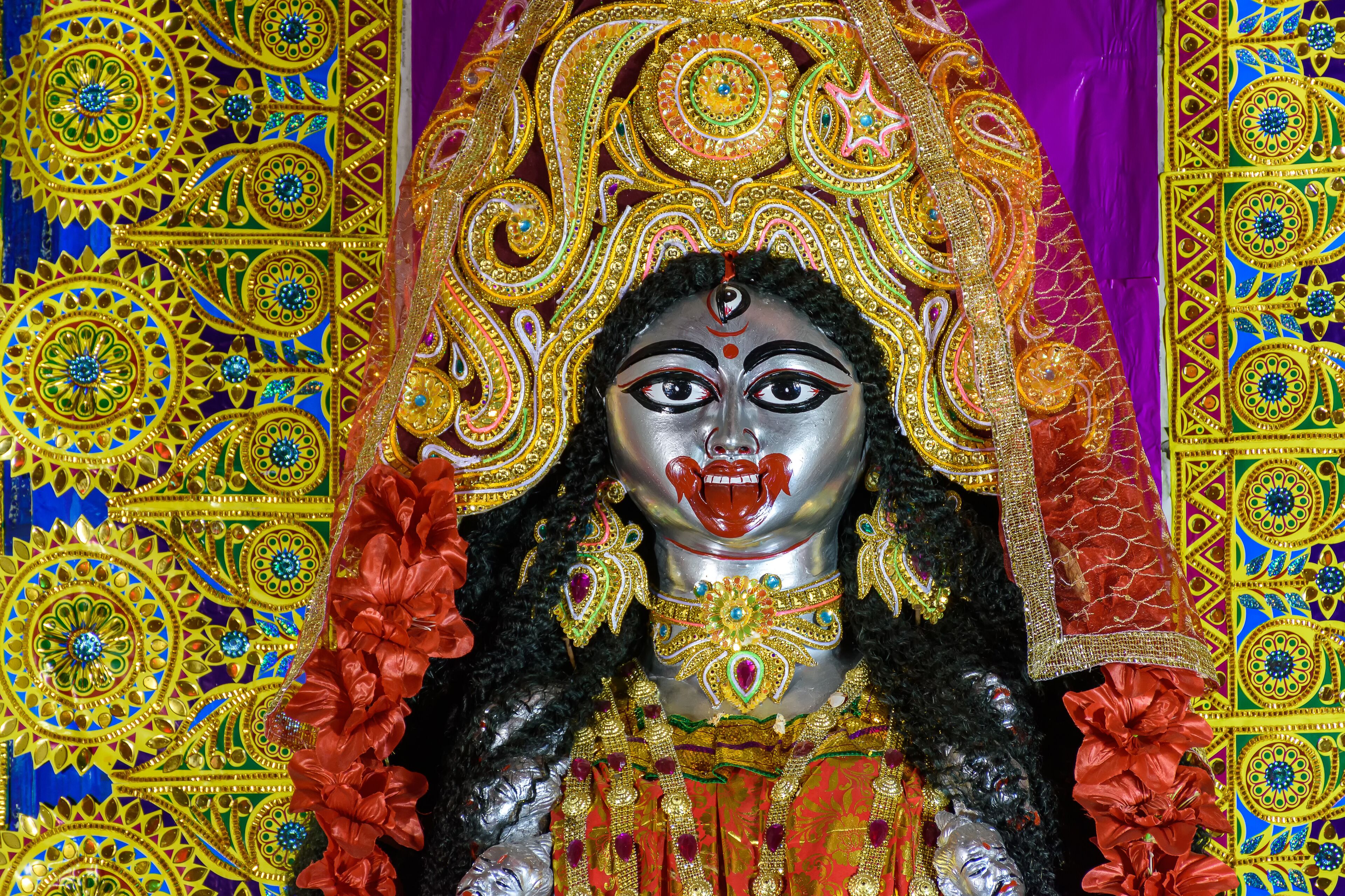 A colorful, intricately decorated statue with elaborate patterns and jewelry.