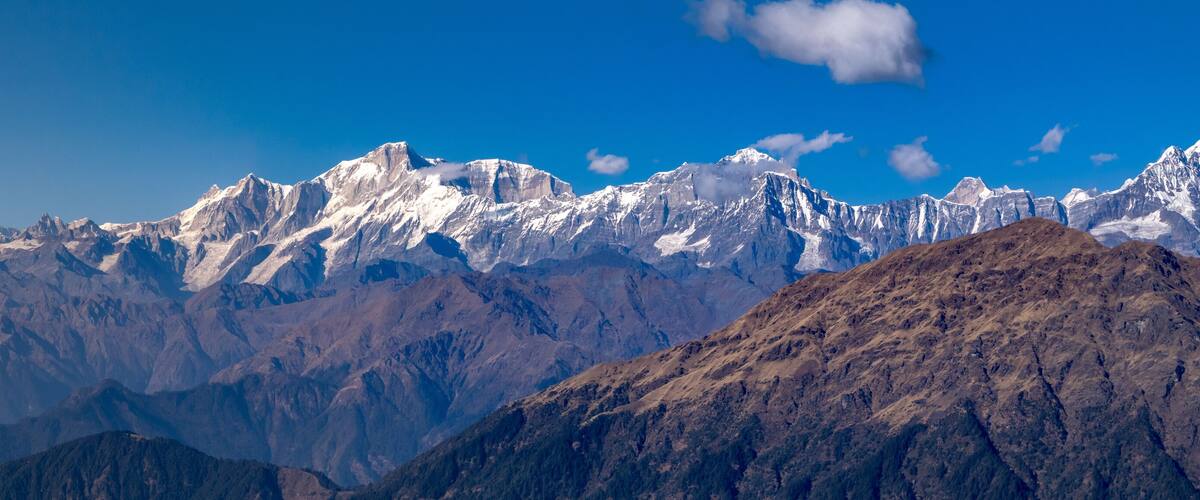 A range of snow-capped mountains under a clear blue sky.