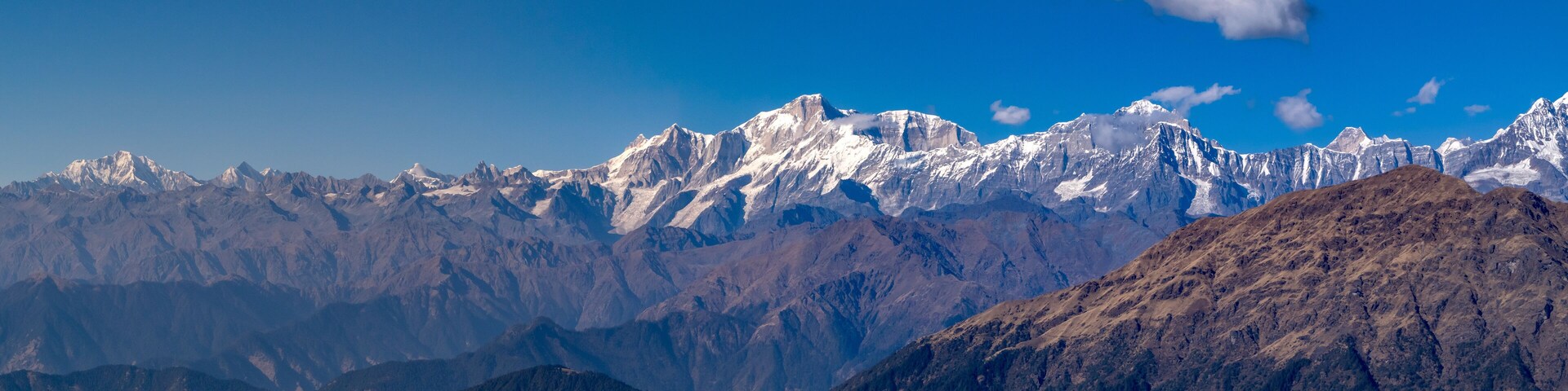 A range of snow-capped mountains under a clear blue sky.