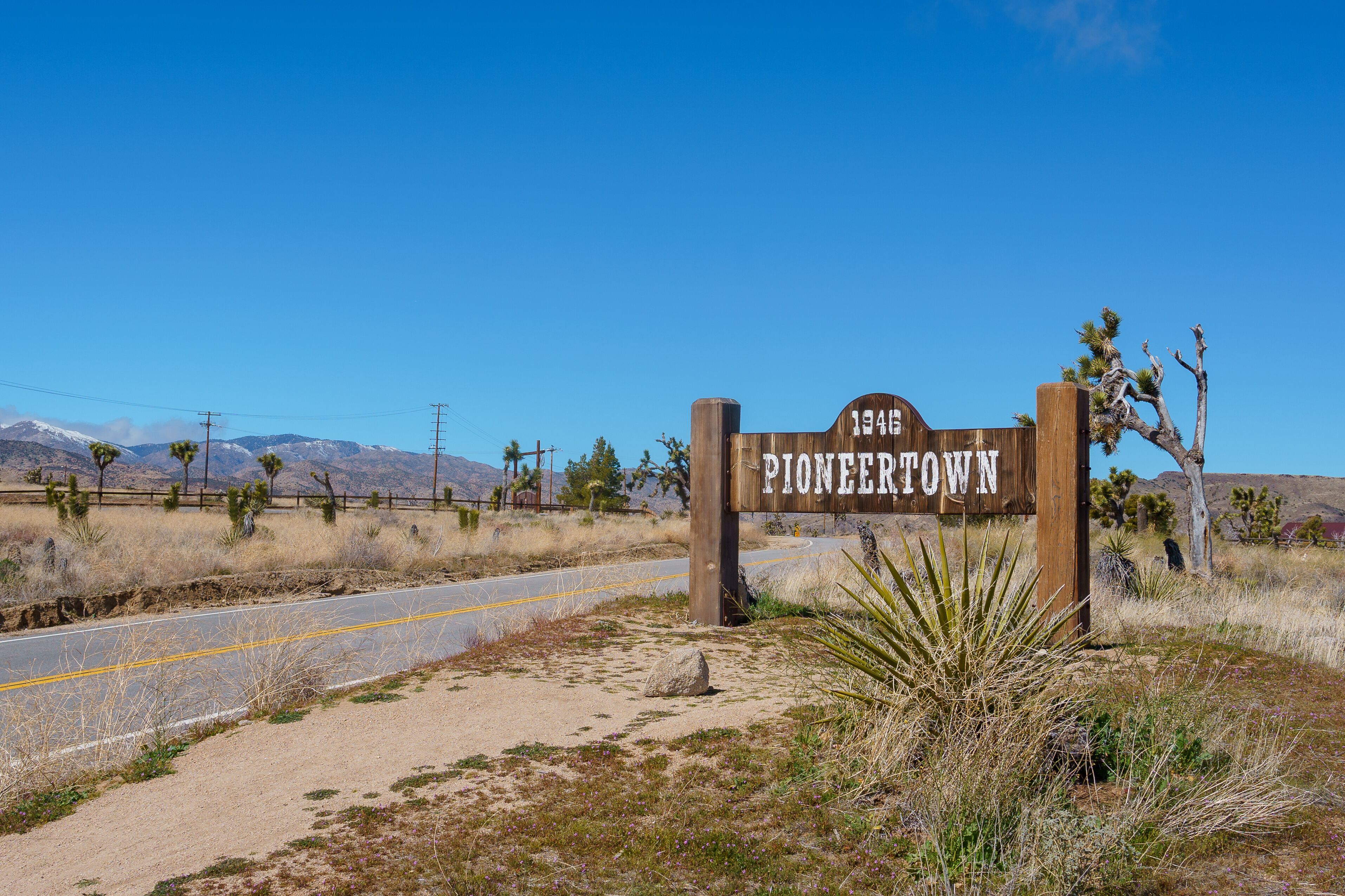 Pioneertown California welcome sign next to a paved road