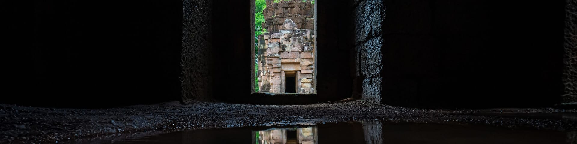 Main Tower of Prasat Ta Muean Tot view from in the archway. It is The Arokayasala or Hospital with Ancient Khmer Art of Bayon Style.