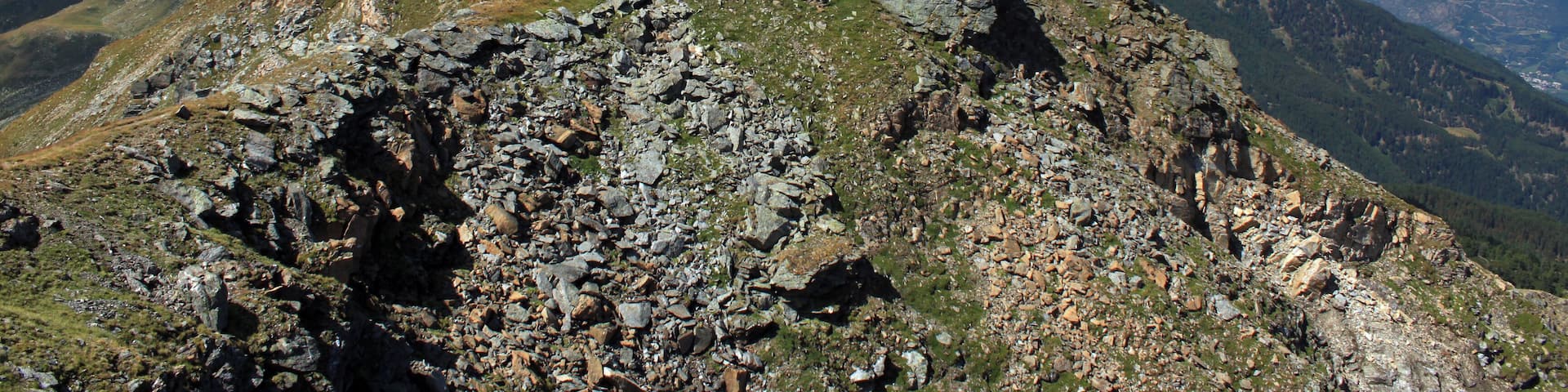 Auf dem Gipfel der Naturnser Hochwart (2608 m.ü.M.). Der Blick geht hier auf dem Gipfelkamm in Richtung Westen ins Ortlergebiet. Rechts unten liegt der Vinschgau. Die Naturnser Hochwart (italienisch Guardia Alta) ist ein 2608 Meter hoher Berg im Zufrittkamm der Ortler-Alpen. Die Hochwart befindet sich im italienischen Südtirol und trennt die Vinschger Gemeinde Naturns von der Ultner St. Pankraz.