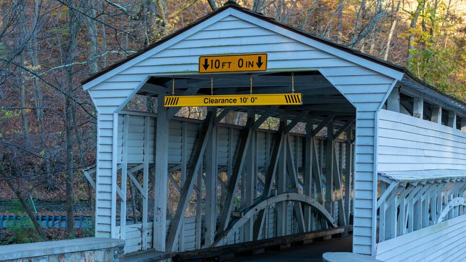 A white covered bridge with a 10-foot clearance sign.