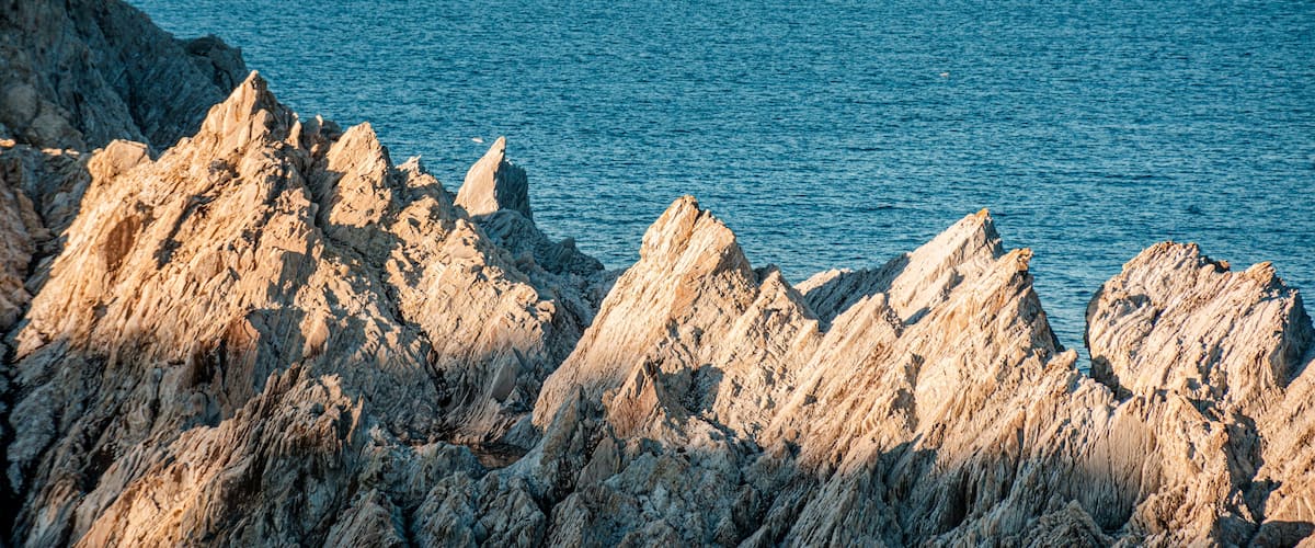 Rugged coastal cliffs with a clear view of the ocean.