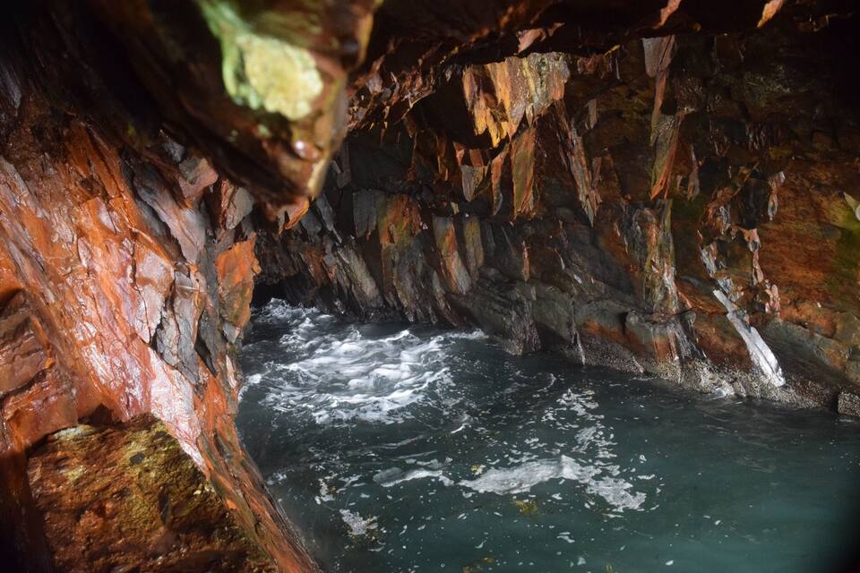 A cave with a flowing river inside.