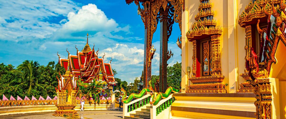 A traditional Thai temple with ornate architecture, including golden spires and intricate designs.