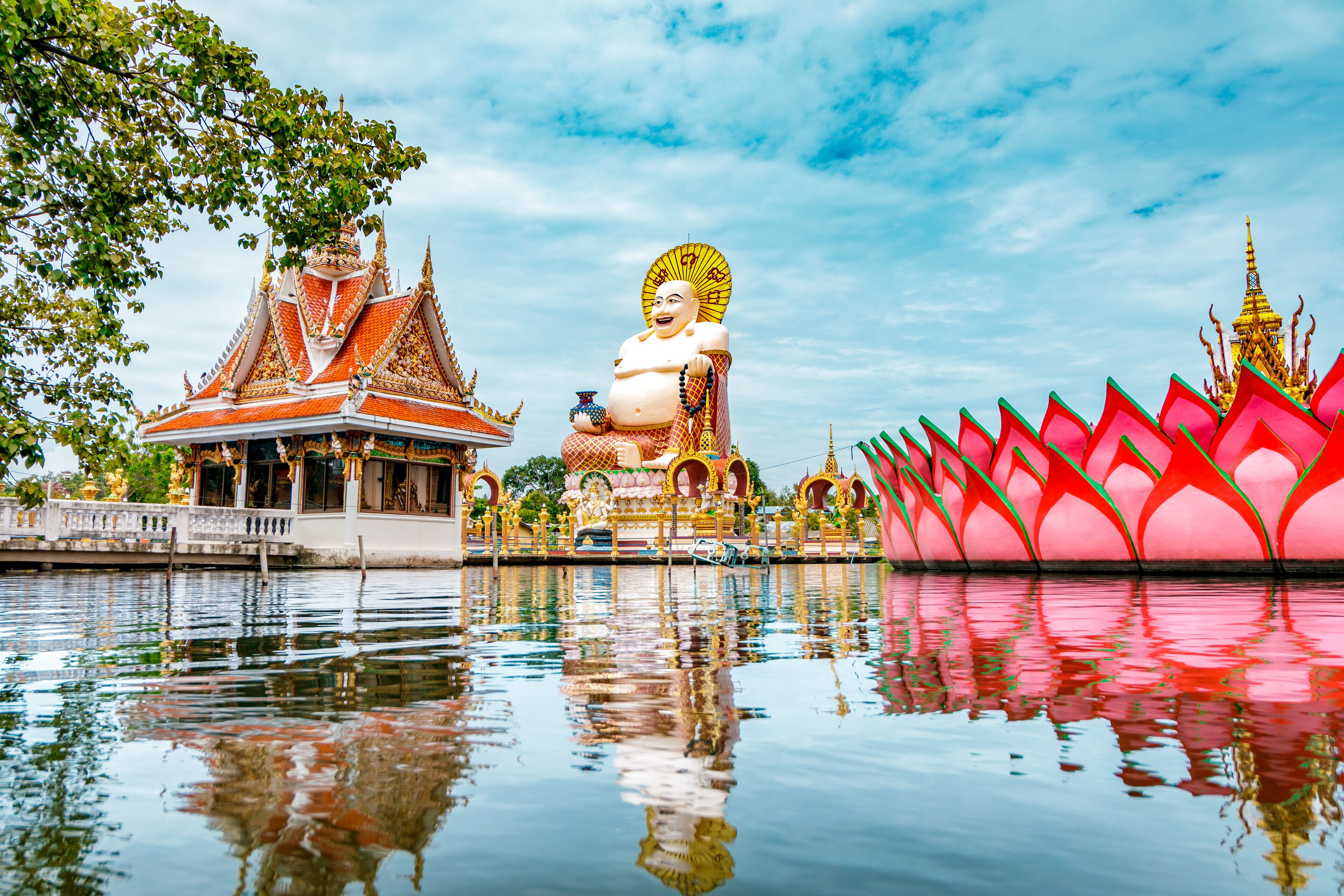 Wat Plai Laem Buddhism Temple statues during a bright sunny day with lake in the foreground in Koh Samui, Surat Thani, Thailand 