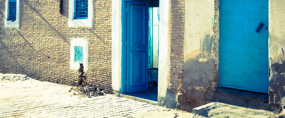 A brick building with blue doors and windows.