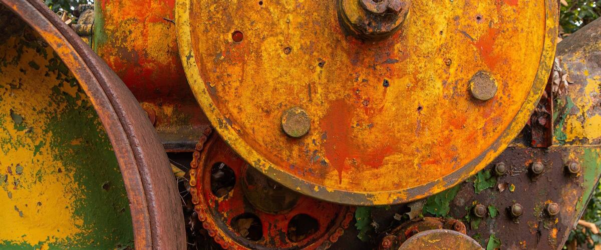A rusted mechanical part with a chain and bolts.