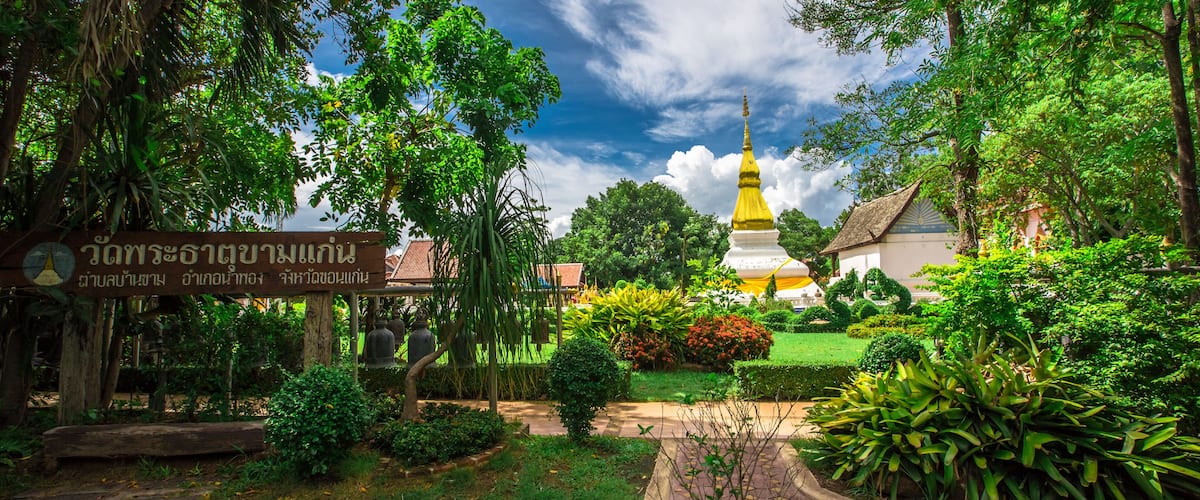 A temple surrounded by lush greenery and a clear sky.