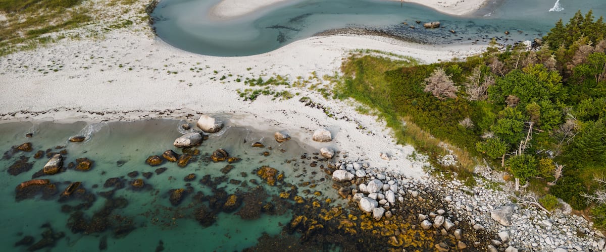 A river winding through a sandy landscape with rocky outcrops and dense greenery.