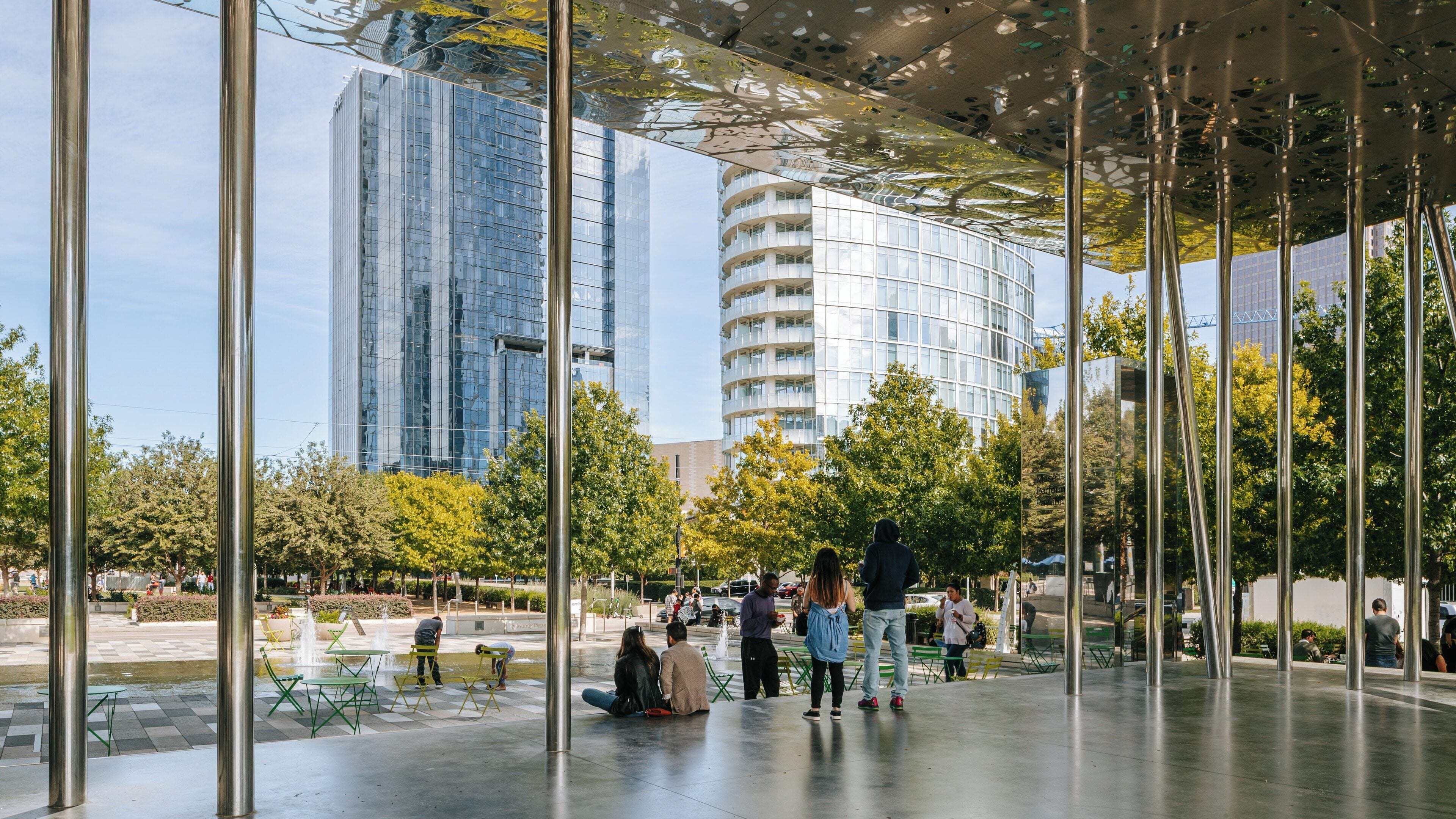 Visiting Klyde Warren Park in the Dallas Arts District showcases urban leisure activities and cityscape views on a sunny day