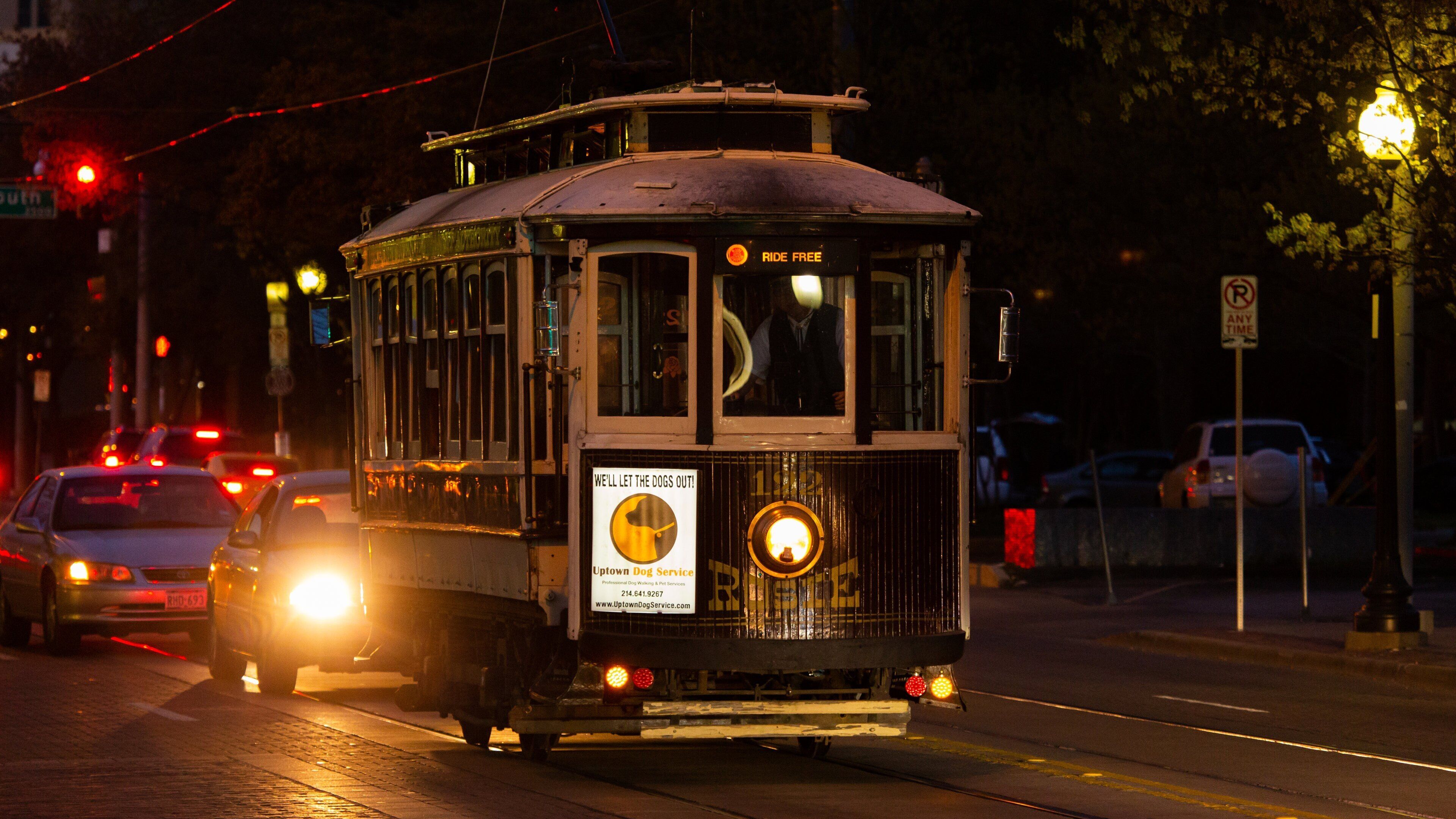 A vintage streetcar with a sign that reads "Ride Free" and another sign advertising the Uptown Dog Service.