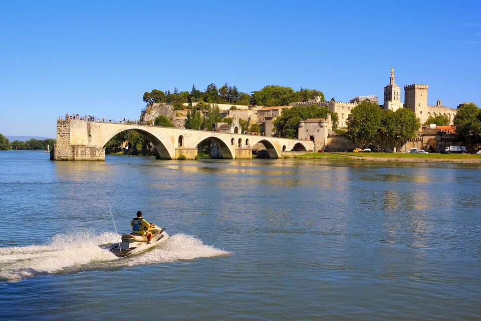 A bridge over a river with a castle in the background.