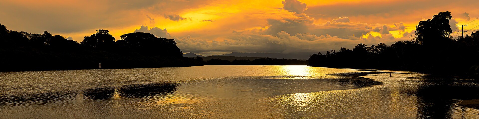 A sunset over a calm river with reflections of the sky.
