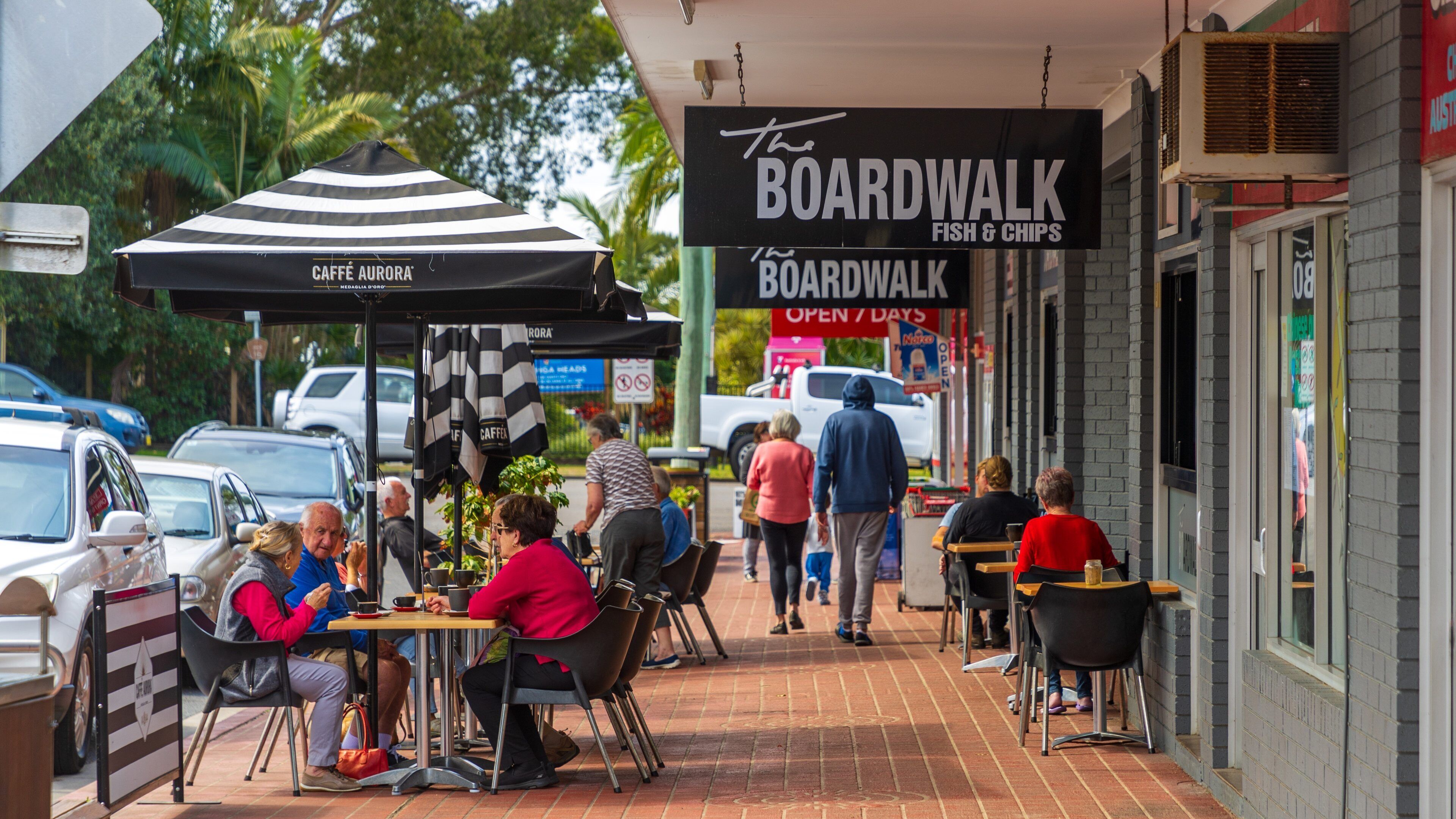 Urunga featuring street scenes and outdoor eating as well as a couple
