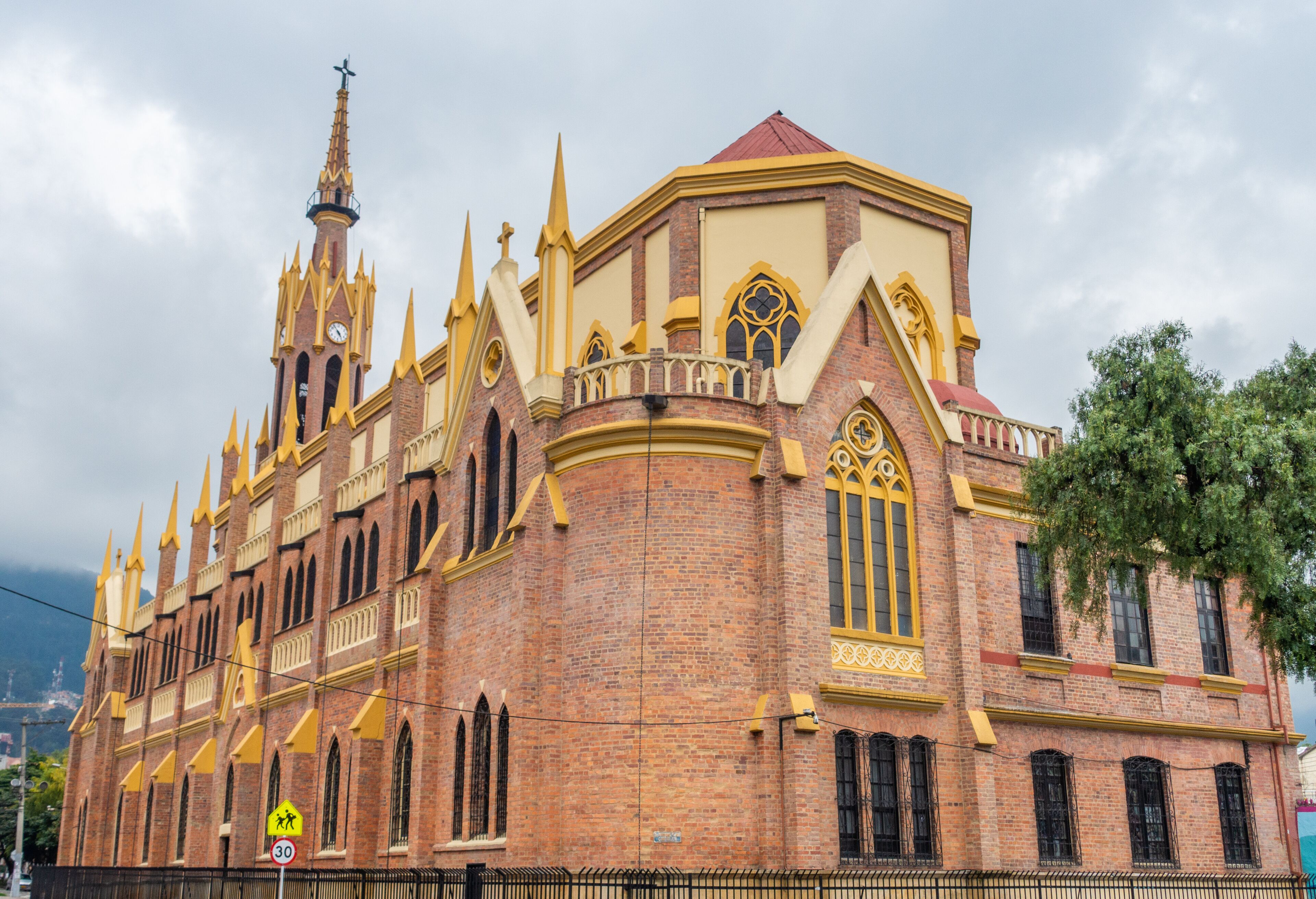 A historic church with a tall spire, ornate windows, and a brick facade.