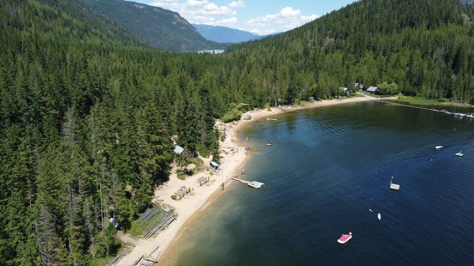 A lake surrounded by dense forest and mountains.