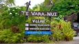A sign for Te Vara-Nui Village with directions to the Cultural Village Centre, Over Water Island Show, and Weddings Venue.