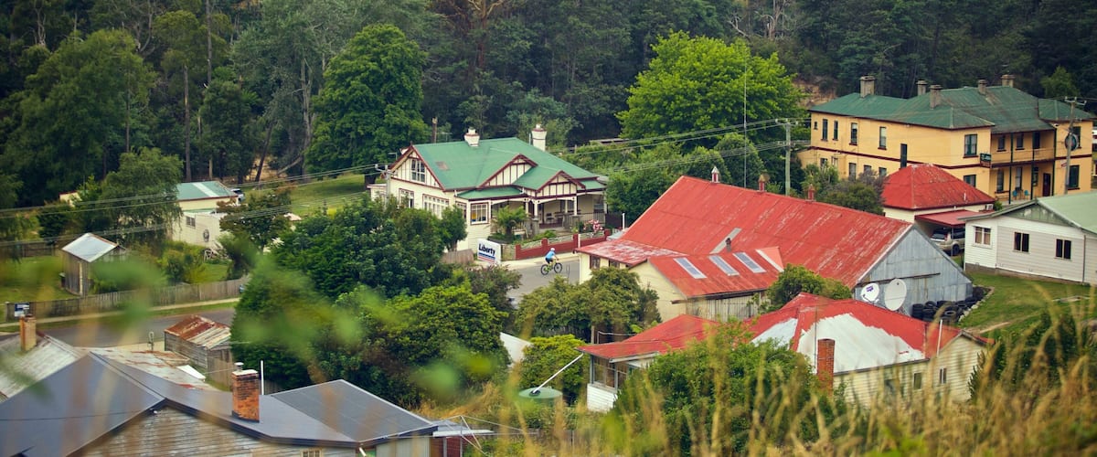 A rural village with houses, a prominent yellow building, and a green-roofed house.