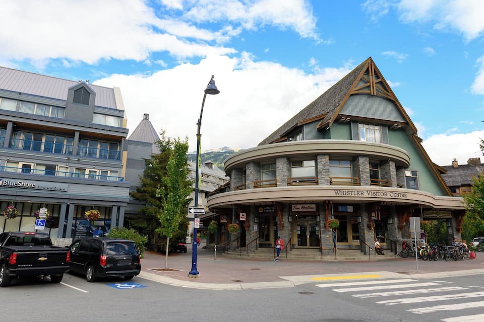 A building with a curved facade and a triangular roof, labeled "Whistler Visitor Centre."