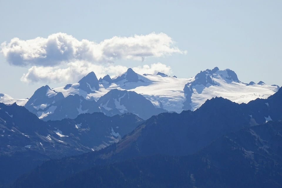 Cordillera montañosa con picos nevados y cielo despejado.