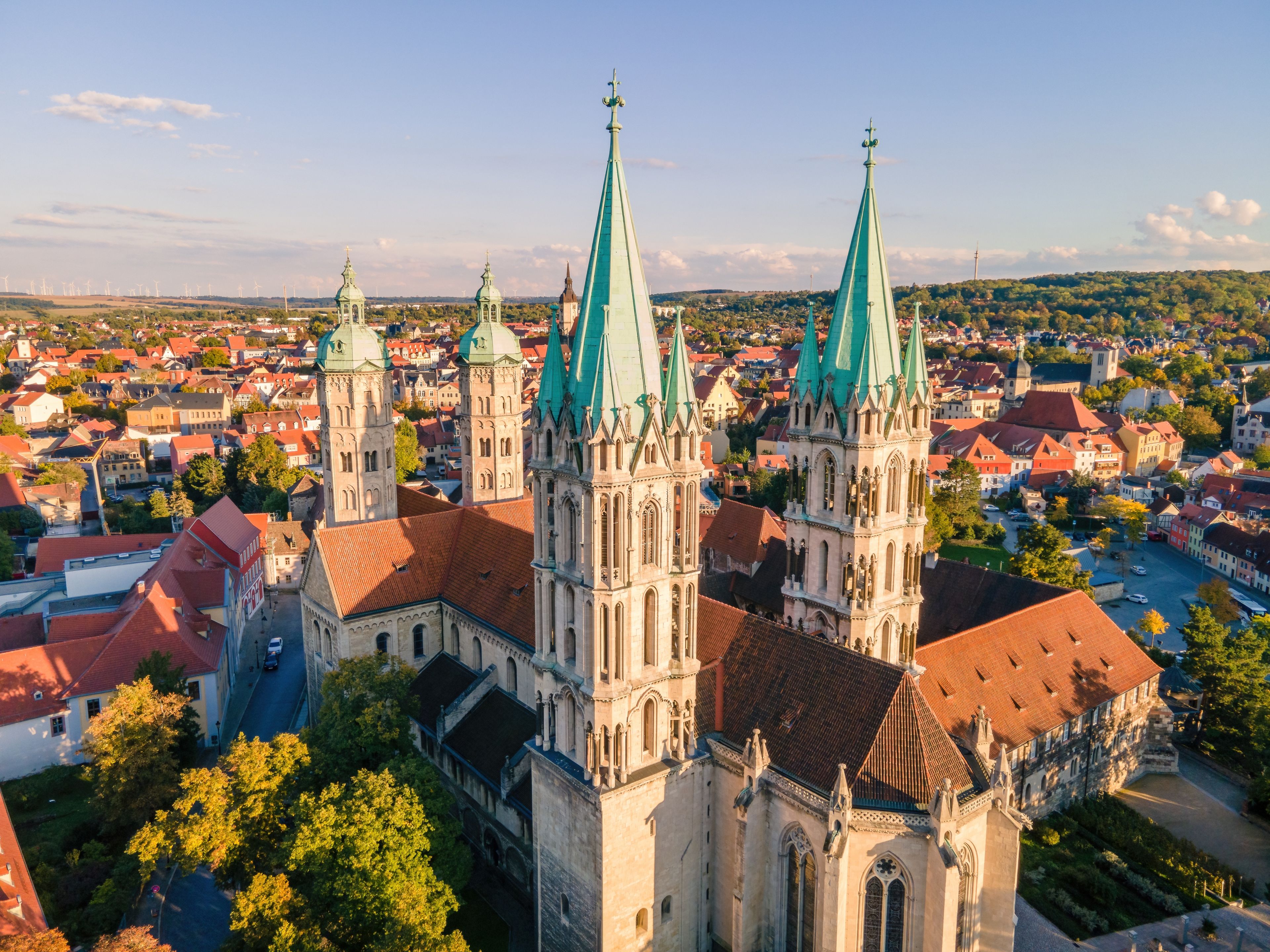 Eine Kathedrale mit mehreren Türmen und einer Stadt im Hintergrund.