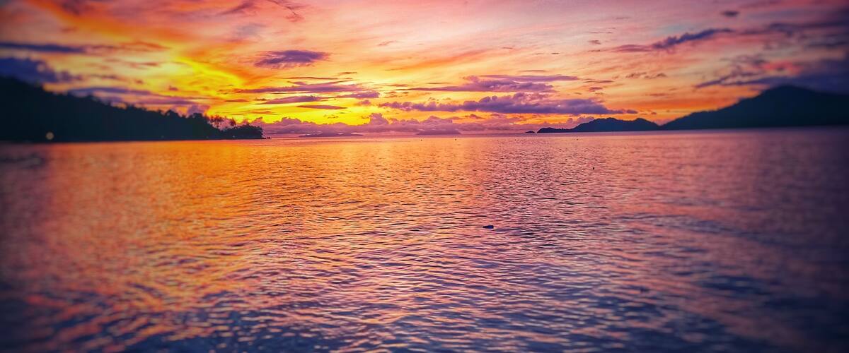 A sunset over a calm lake with vibrant colors reflecting on the water.