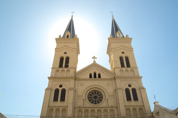 Une église dotée de deux tours et d’une grande fenêtre centrale.