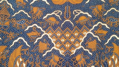 Traditional batik pattern with brown and navy blue tones featuring floral and animal motifs. Batik Cuwiri. Perfect for textile, background, cultural, and ethnic design projects.
