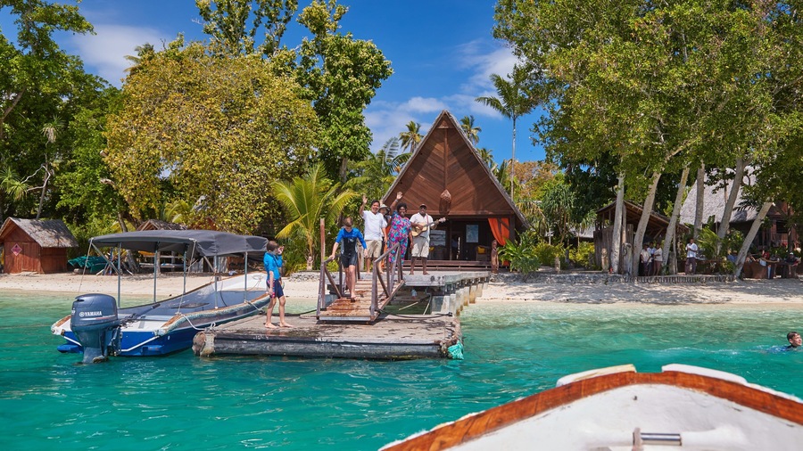 Ratua Island which includes a beach and tropical scenes as well as a small group of people