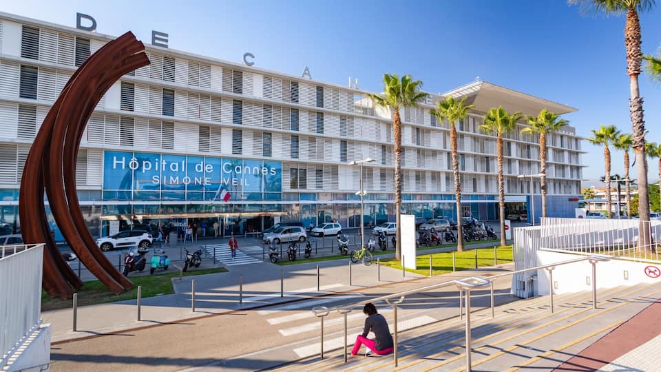 Un moderno edificio hospitalario con una gran escultura en su fachada.