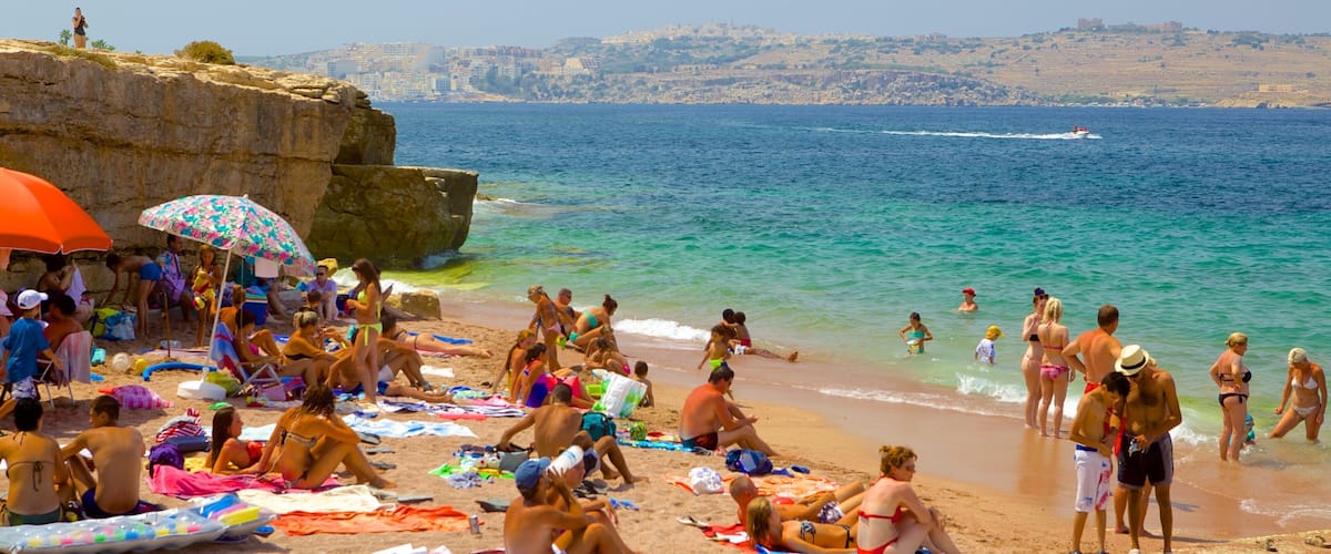 Spiaggia di Bugibba mostrando spiaggia cosi come un grande gruppo di persone