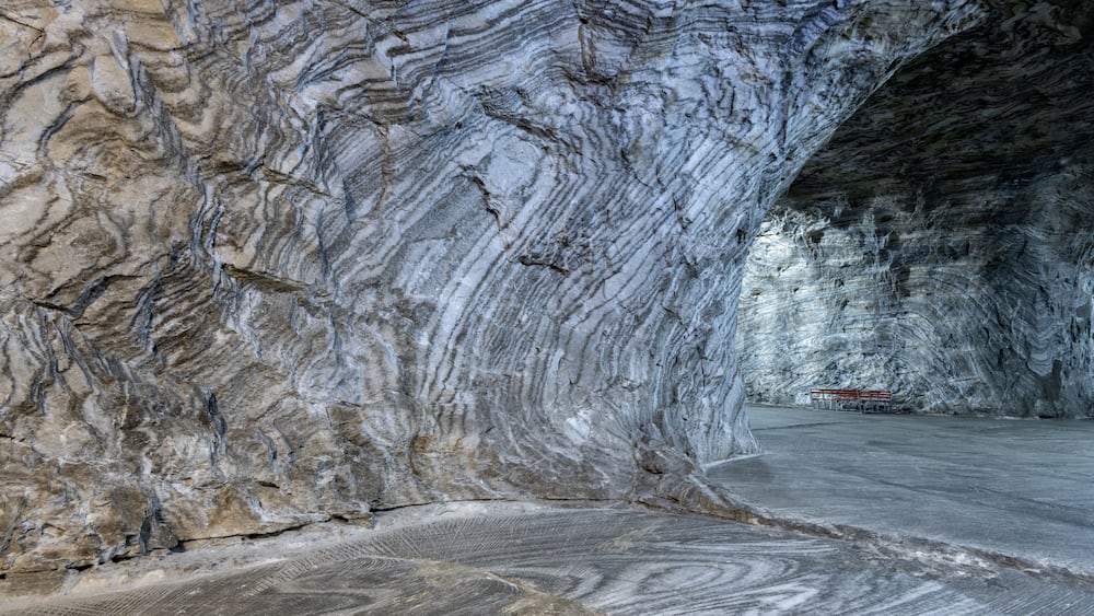 Eine Marmorhöhle mit einer Bank und einem Weg.