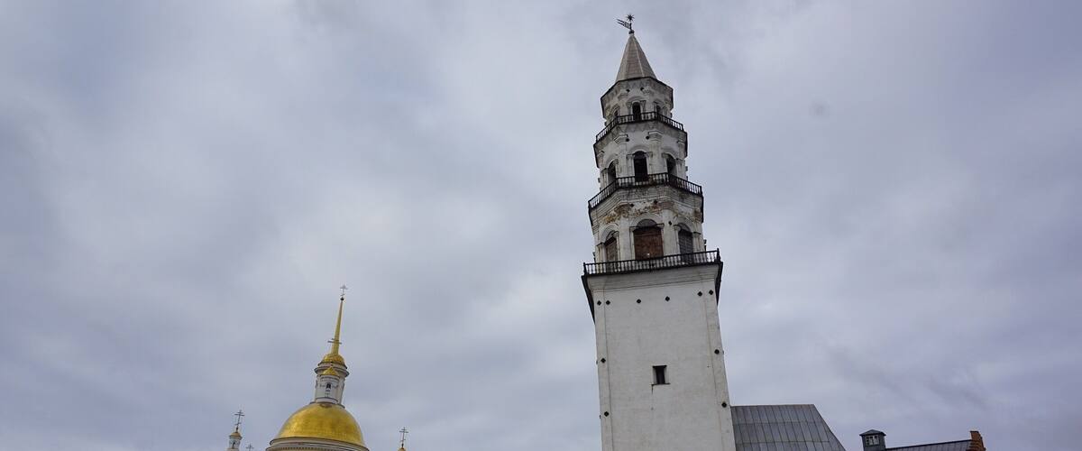 A historic building with a tall tower and golden domes.