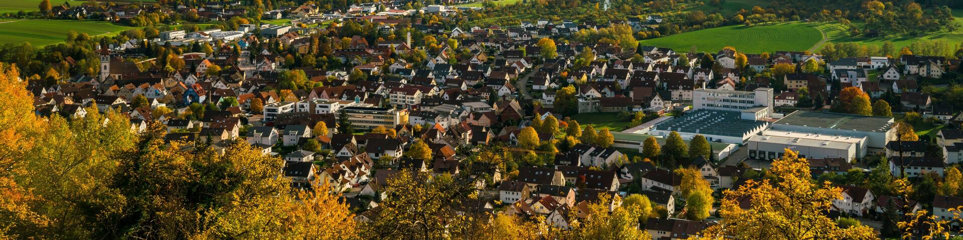 Germany, Aerial wide view above houses of city rudersberg in wieslauf valley surrounded by swabian forest nature landscape in autumn
