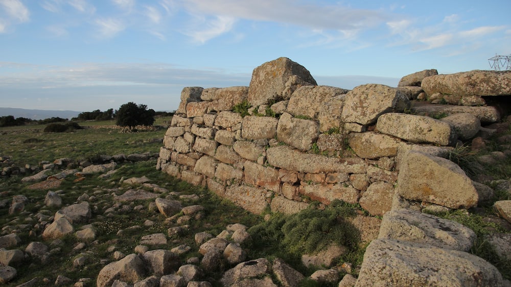 Un mur de pierres, composé de gros rochers et d’une végétation clairsemée.
