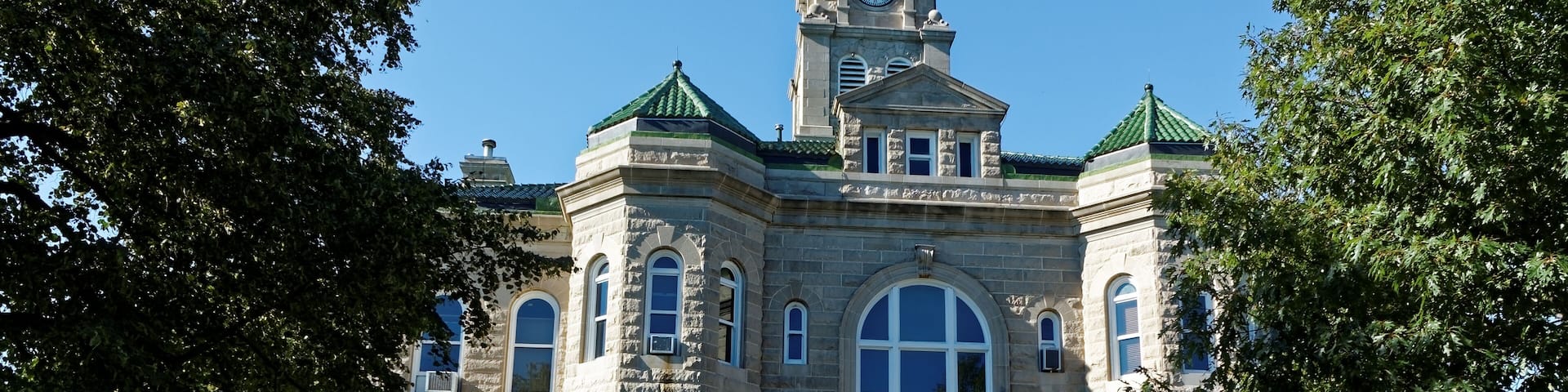 The Appanoose County Courthouse rises between the trees. This courthouse has served the county since 1904.