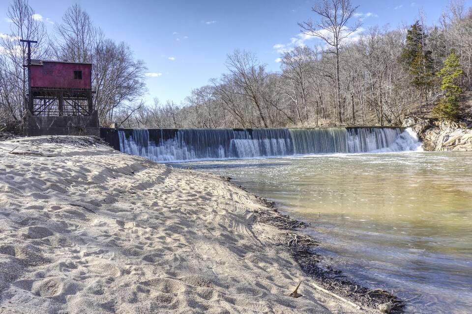 A waterfall, sandy beach, and a red building.