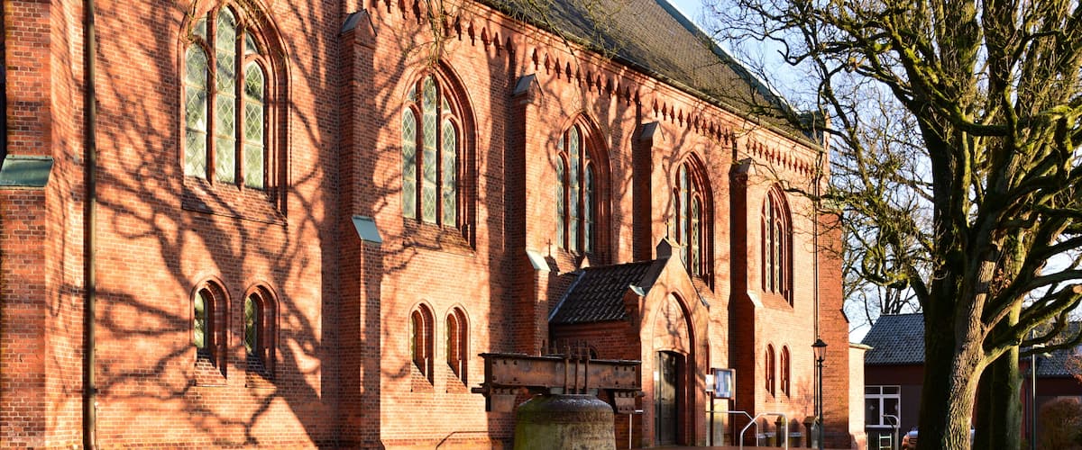A red brick church with arched windows and a bell tower.