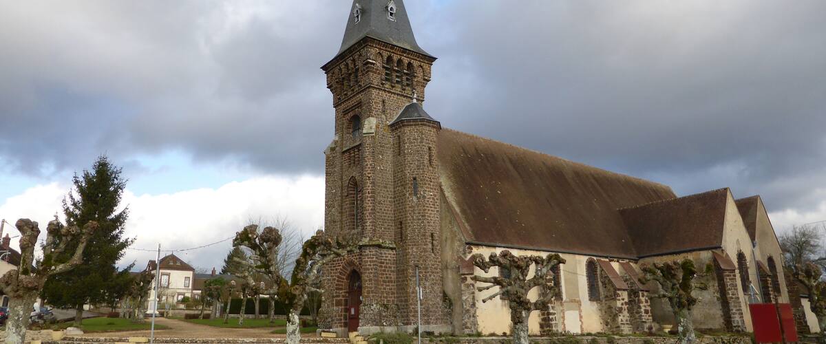 A historic church with a tall tower and a large bell.